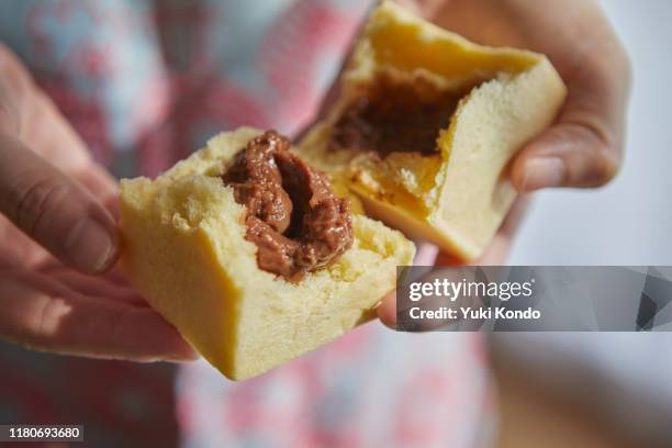 a hand that breaks a cubic bread. - finger bun stock pictures, royalty-free photos & images