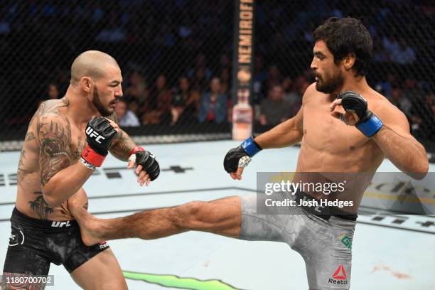 Kron Gracie of Brazil kicks Cub Swanson in their featherweight bout during the UFC Fight Night event at Amalie Arena on October 12, 2019 in Tampa,...