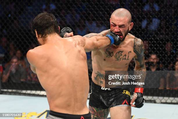 Cub Swanson and Kron Gracie of Brazil exchange punches in their featherweight bout during the UFC Fight Night event at Amalie Arena on October 12,...