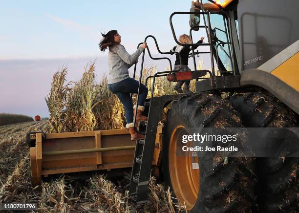 Ashley Schnieders and Arabelle Schnieders join Troy Koehler as he drives a combine during the corn harvest in a field at the Hansen Family Farms on...