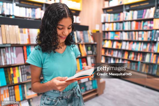 student reading book in library - reading imagens e fotografias de stock