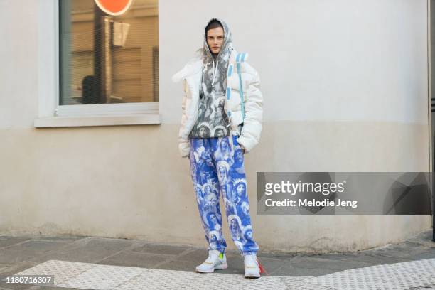 Model Giedre Dukauskaite wears a white puffer jacket, gray Jesus print Supreme hoodie, blue Supreme Jesus And Mary Sweatpants, and white Off-White...