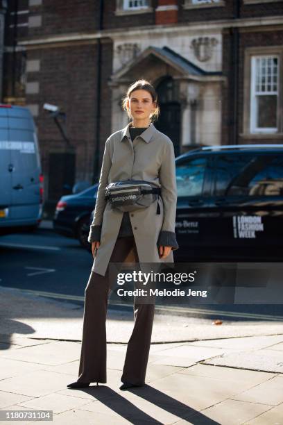 Model Giedre Dukauskaite wears a gray jacket, Patagonia fanny pack,, and brown trousers after Victoria Beckham during London Fashion Week February...