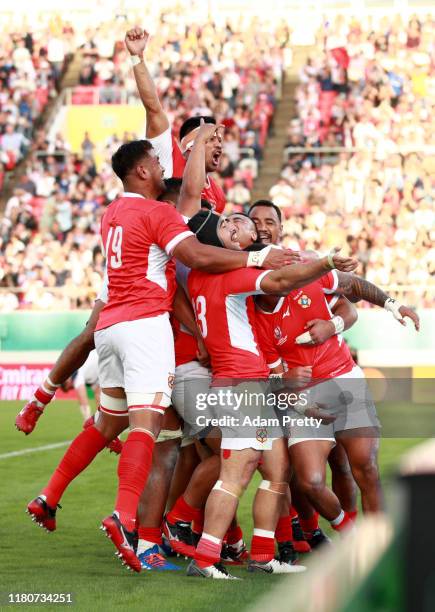 Telusa Veainu of Tonga is congratulated by teammates after scoring his team's fourth try during the Rugby World Cup 2019 Group C game between USA and...
