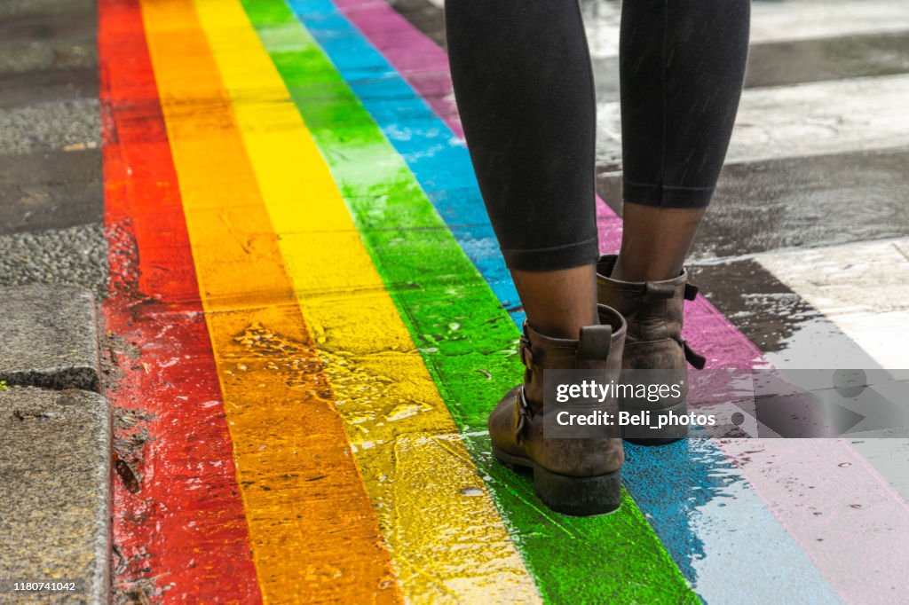 Benen lopen op Gay Rainbow crosswalk.