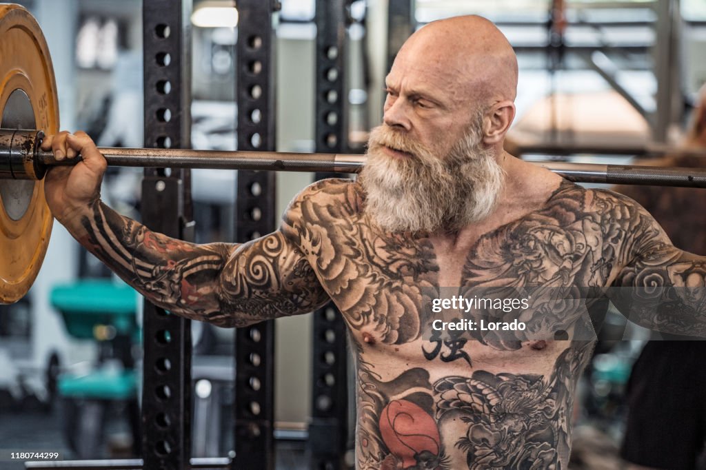 Fermez-vous vers le haut du portrait de l'homme aîné tatoué pendant l'entraînement de gymnastique