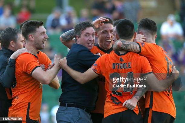 Robbie Fowler coach of the Roar celebrates with his players after a gaol by Roy O"Donovan of the Roar during the round one A-League match between...