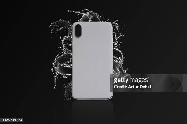 studio shot of waterproof phone with water splash in black background. - back shot position - fotografias e filmes do acervo