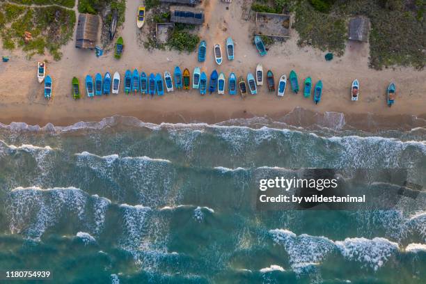 aerial view of the fishing boats on the beach in a small coastal village near trincomalee, sri lanka. - fishing village photos et images de collection