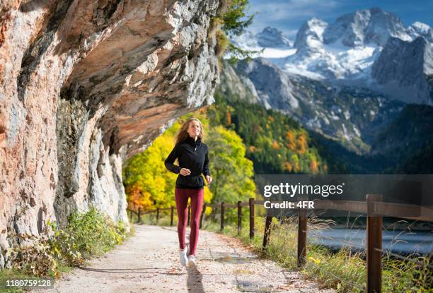 outdoor fitness, athletic woman trail running - salzkammergut stock pictures, royalty-free photos & images