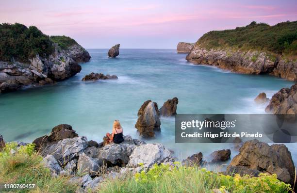 a woman in buelna beach at sunset, barro, asturias, llanes, spain. - llanes stock-fotos und bilder