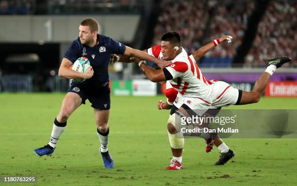 Finn Russell of Scotland hands off Jiwon Koo of Japan as he scores their first try during the Rugby World Cup 2019 Group A game between Japan and...