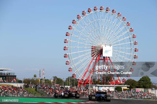 Lewis Hamilton of Great Britain driving the Mercedes AMG Petronas F1 Team Mercedes W10 and Antonio Giovinazzi of Italy driving the Alfa Romeo Racing...