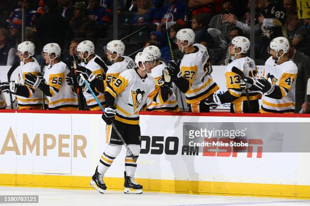 Jared McCann of the Pittsburgh Penguins is congratulated by his teammates after scoring a goal against the New York Islanders during the third period...