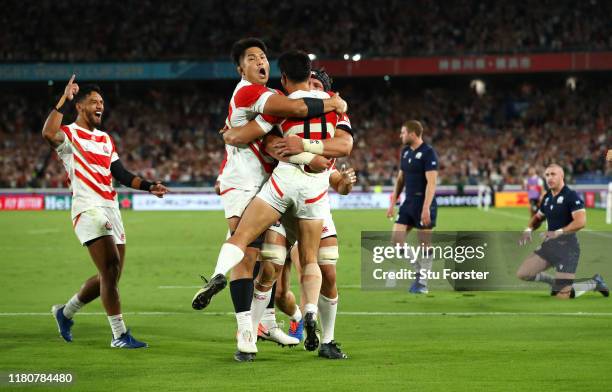 Kenki Fukuoka of Japan celebrates with team mates as he scores their third try as Scotland players Stuart Hogg and Finn Russell react during the...