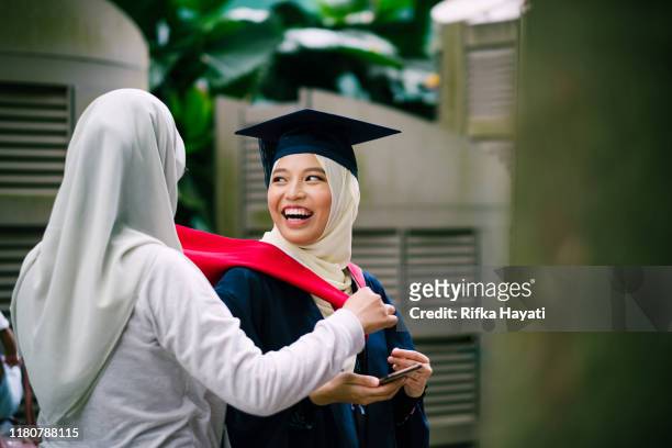 young asian women friend's helping with her graduation gown - malaysia school stock pictures, royalty-free photos & images