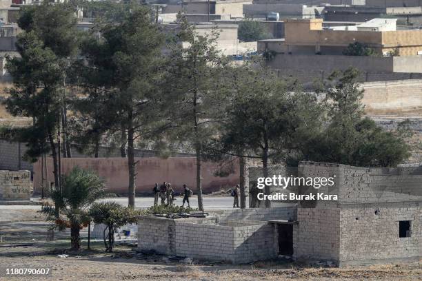 Members of Turkish-backed Free Syrian Army, a militant group active in parts of northwest Syria advance in Syrian city of Tel Abyad, as seen from the...