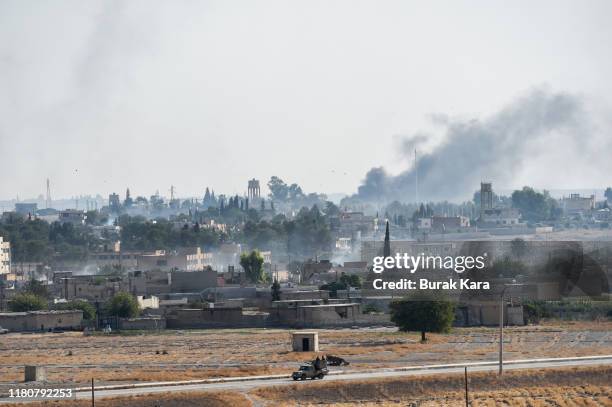 Members of Turkish-backed Free Syrian Army, a militant group active in parts of northwest Syria advance in Syrian city of Tel Abyad, as seen from the...