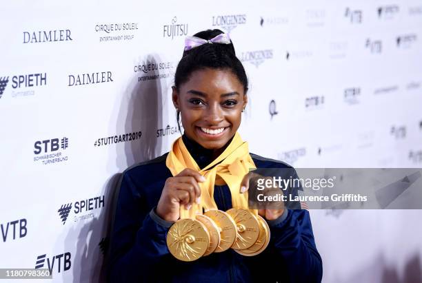 Simone Biles of The United States poses for photos with her multiple gold medals during day 10 of the 49th FIG Artistic Gymnastics World...