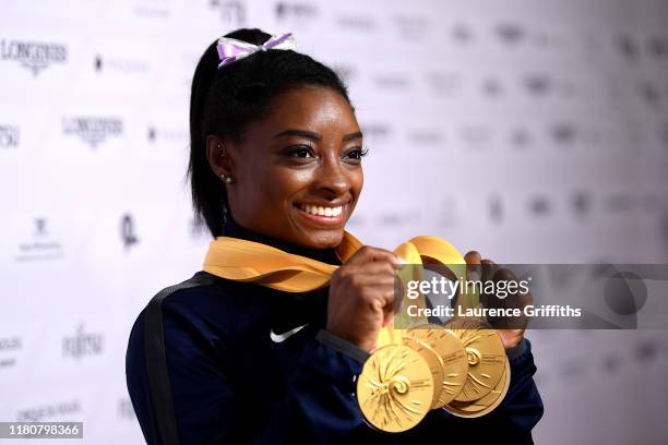 Simone Biles of The United States poses for photos with her multiple gold medals during day 10 of the 49th FIG Artistic Gymnastics World...