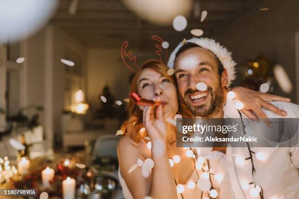 het is kersttijd - couple at home stockfoto's en -beelden