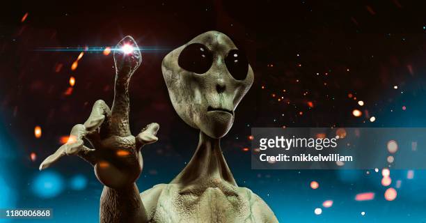 alien from outer space stands before sky filled with stars trying to communicate - invader stock pictures, royalty-free photos & images
