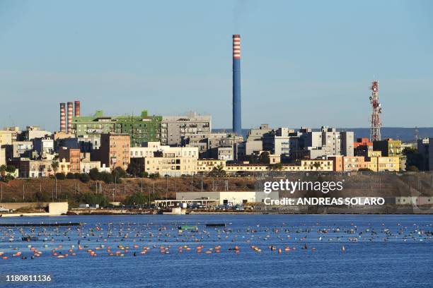 This picture taken on November 8 shows a general view of the mineral park at the ArcelorMittal Italia steel plant seen past the Tamburi residential...