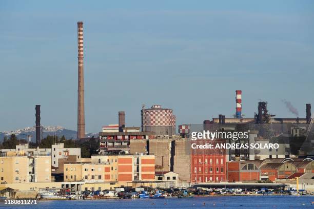 This picture taken on November 8 shows a general view of the ArcelorMittal Italia steel plant seen past the Tamburi residential district in Taranto,...
