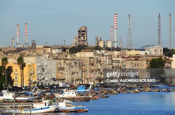 This picture taken on November 8 shows a general view of the ArcelorMittal Italia steel plant seen past the Tamburi residential district in Taranto,...