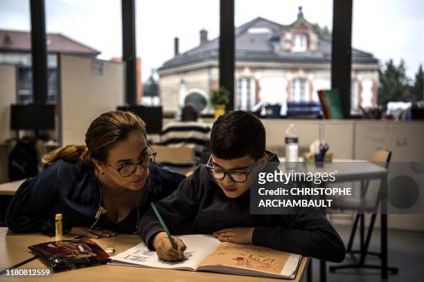 An autistic child Mounib attends a course delivered by a specialised teacher Caroline Berge at the College du Parc in Aulnay-sous-Bois, northeast of...