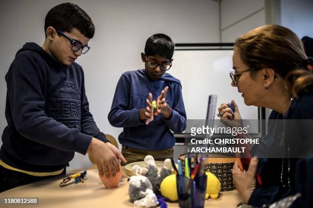 Autistic children Mounib and Sanjay attend a course delivered by a specialised teacher Caroline Berge at the College du Parc in Aulnay-sous-Bois,...