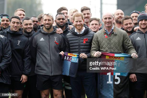 Prince Harry, Duke of Sussex and former rugby player Gareth Thomas pose with gift shirts next to Harlequin rugby club members and their captain Chris...