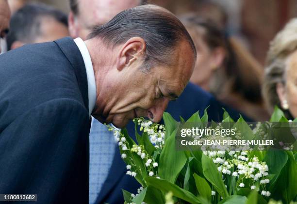 Le président Jacques Chirac participe, le 1er mai 2004 au Palais de l'Elysée à Paris, à la traditionnelle cérémonie de remise du muguet. AFP PHOTO...