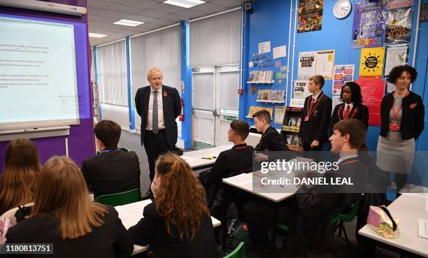 Britain's Prime Minister Boris Johnson reacts as he observes a school lesson during a general election campaign visit to George Spencer Academy, west...