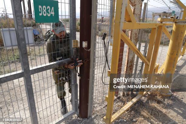 Picture taken on November 8 shows an Israeli soldier closing a border gate on the Israeli side of the border at the Jordan Valley site of Naharayim,...