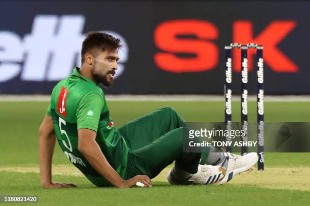 Pakistan's paceman Mohammad Amir slips as he bowls during the Twenty20 cricket match between Australia and Pakistan at Optus Stadium in Perth on...