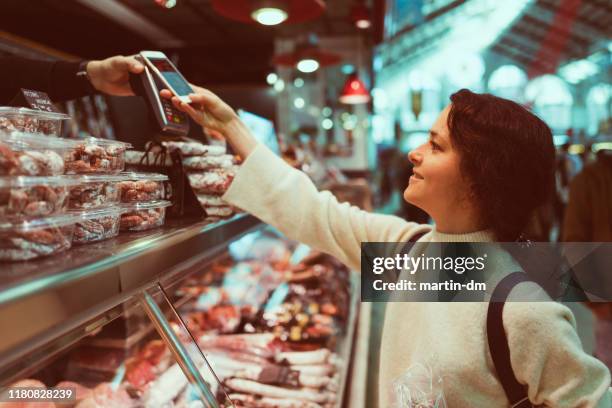 woman paying contactless at the farmer's market - cultivated meat stock pictures, royalty-free photos & images