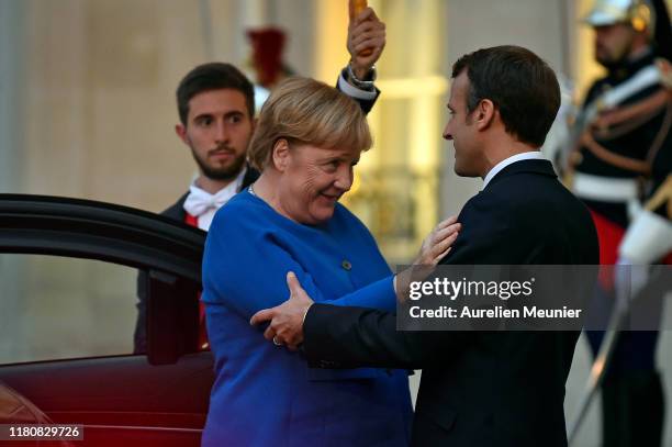 French President Emmanuel Macron welcomes German Chancelor Angela Merkel for a meeting at Elysee Palace on October 13, 2019 in Paris, France....