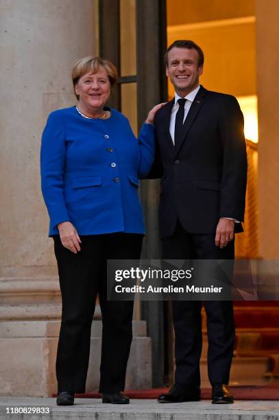 French President Emmanuel Macron welcomes German Chancelor Angela Merkel for a meeting at Elysee Palace on October 13, 2019 in Paris, France....