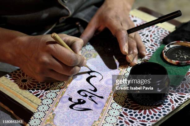 close-up of man writing arabic calligraphy - arabic style stock pictures, royalty-free photos & images