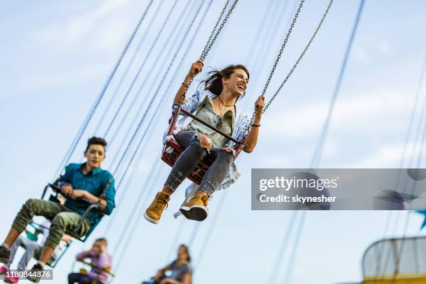 below view of happy woman having fun on chain swing ride. - carrossel imagens e fotografias de stock