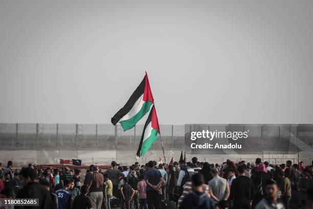 Palestinian protesters holds up Palesinian flags during the "Great March of Return" at Israel-Gaza border near Shuja'iyya neighbourhood of Gaza City,...