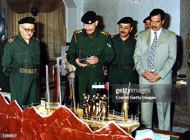 Iraqi Deputy Prime Minister Tariq Aziz, Vice President Taha Yassein Ramadan, Izat Ibrahim and President Saddam Hussein receive a gift from the Ba?th...