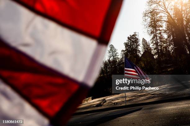 American flags fly along Skyway Road, in front of still empty lots, during the one year anniversary of the Camp Fire on November 8, 2019 in Paradise,...