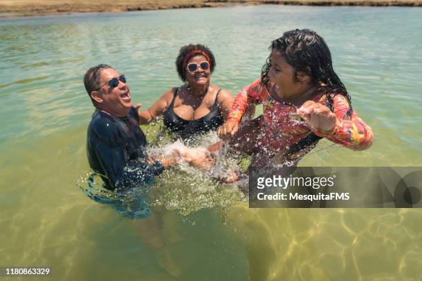 family having fun in the coral pools at tropical beach - swimsuit models girls stock pictures, royalty-free photos & images