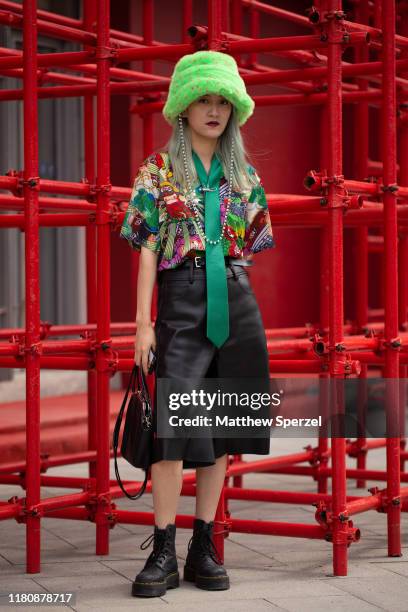 Guest is seen on the street attending Labelhood during Shanghai Fashion Week wearing neon green faux fur hat, colorful print shirt, long green silk...