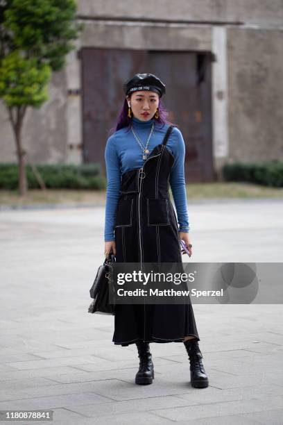 Guest is seen on the street attending Labelhood during Shanghai Fashion Week wearing cobalt turtleneck, black dress, black/grey bag, black boots,...