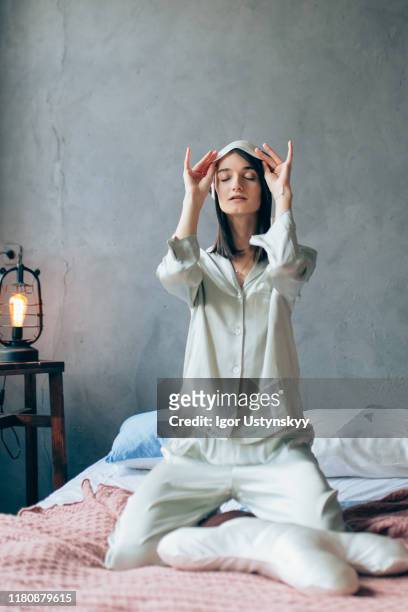 young beautiful woman lifting up sleep mask - silk pajamas stock pictures, royalty-free photos & images