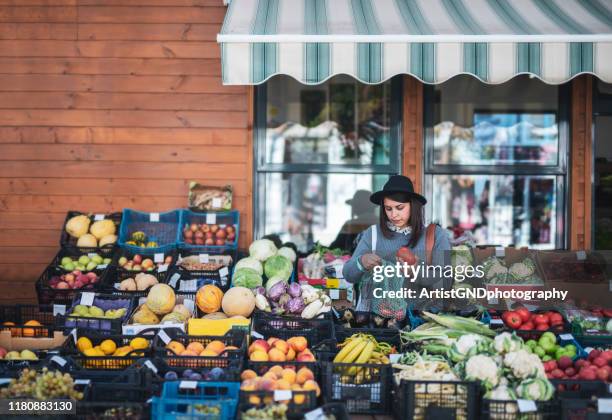 woman buying fruit and vegetables - fruit stand stock pictures, royalty-free photos & images