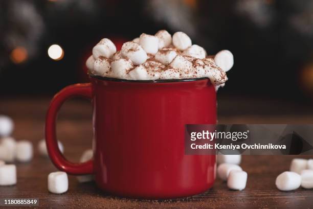 christmas cocoa header with marshmallows, chocolate crumbs, and syrup. large coffee cup with homemade hot chocolate. winter drink photography on a dark background - hot chocolate stock pictures, royalty-free photos & images